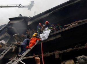 مسعفون ينتشلون جثة من بين انقاض مصنع نشب به حريق خارج داكا يوم السبت. تصوير:  محمد بونير حسين - رويترز